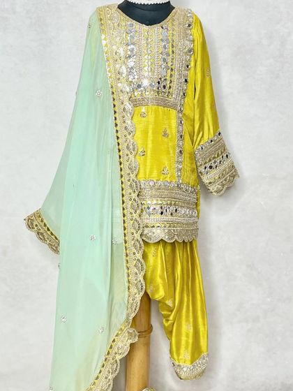 A side view of the yellow mirror work set, highlighting the shimmer of the mirrors and the flow of the dupatta.