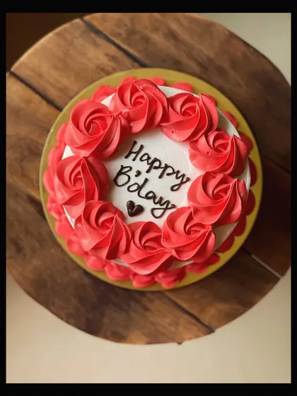 A top-down view of the classic birthday cake with red buttercream roses.