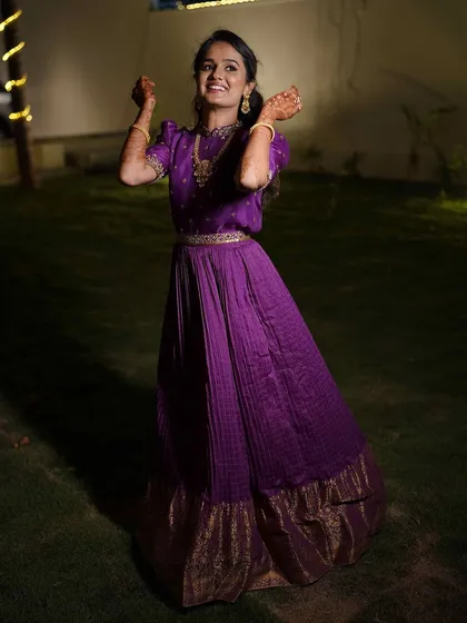 A joyful shot of our client dancing in her purple gown, the pleated skirt creating beautiful movement.