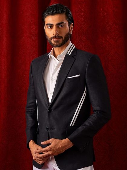 A full portrait of our black blazer with modern white striped accents on the collar and pockets. It's a contemporary twist on a formal classic.