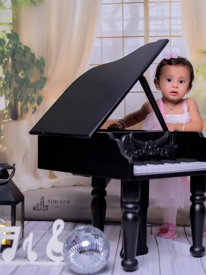 A full-length shot showing the beautiful setup for our baby girl piano session. The soft background and props are carefully chosen to complement the theme.