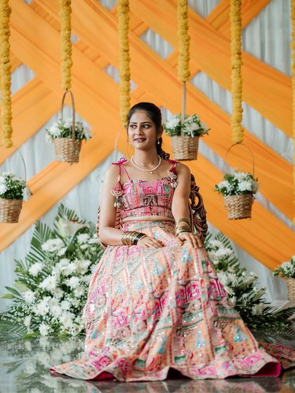 For Chethana's mehendi ceremony, I created this vibrant and playful lehenga. The skirt features colorful patchwork embroidery, and the blouse is designed with a modern tie-up back and charming tassels.