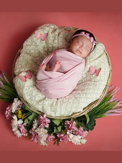 A "snuggle bug" twin newborn shoot done at the client's home in Panvel. This little one is peacefully asleep in a pink swaddle.