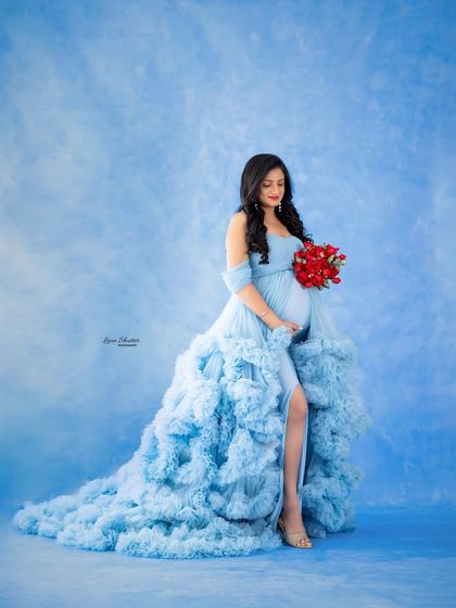 A pop of contrasting color, like this bouquet of red roses against the blue gown, adds visual interest and a touch of romance to this beautiful maternity portrait.