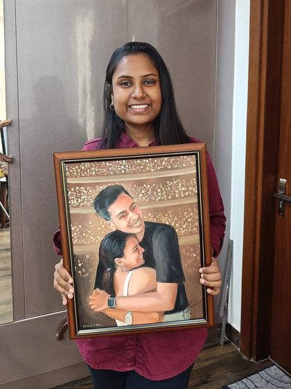 Me holding a finished, framed portrait of a couple in a happy embrace.