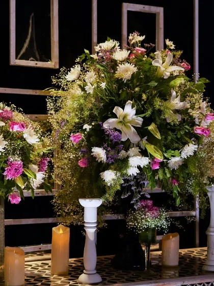 A close-up of the lush, textured floral arrangements, featuring a mix of white lilies, purple statice, and delicate baby's breath.