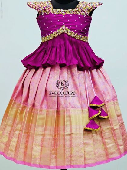 A beautiful pink Pattu Pavadai with a peplum blouse. The skirt has a subtle pattern and a wide gold border, perfect for any special occasion.