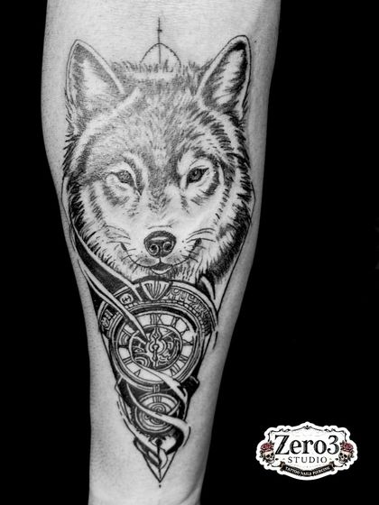A high-contrast, black and white shot of the wolf and clock tattoo, highlighting the deep blacks and detailed shading work.