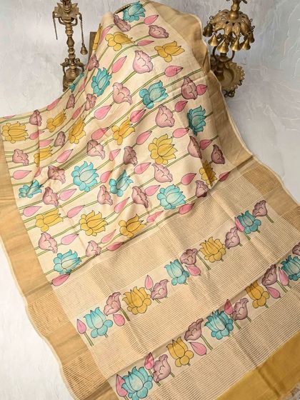 A beautiful Pen Kalamkari saree featuring multi-colored lotus motifs. The soft, earthy tones of the tussar silk provide the perfect backdrop for the delicate hand-painted designs. This is the same as image 18 and 20.