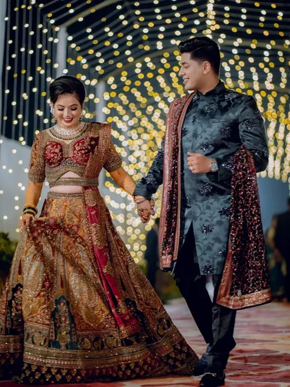 A grand entrance into their new life together. The couple walks hand-in-hand through a magical tunnel of fairy lights, their smiles reflecting the joy of their Sangeet night.