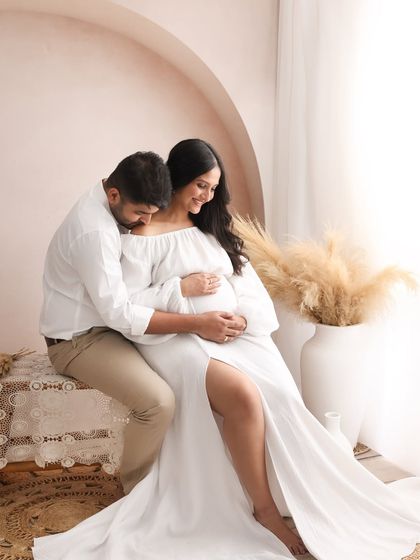A tender kiss on the shoulder speaks volumes. It's these small, unscripted gestures of love and support that I aim to capture during a couple's maternity session.