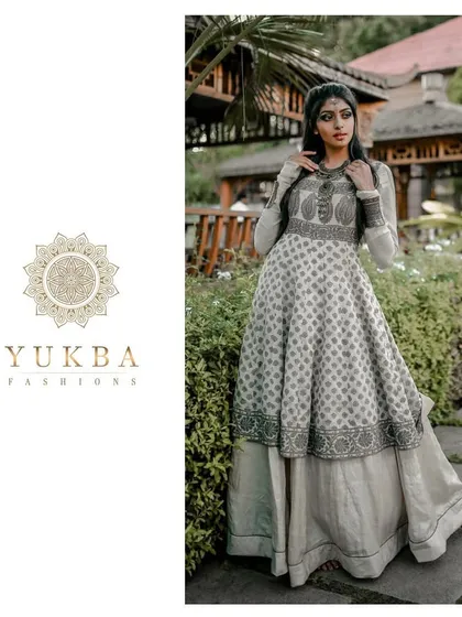 A model showcasing a layered Anarkali gown with block-printed details. The design combines a flowing printed skirt with a structured, embroidered bodice for a unique Indo-Western feel.