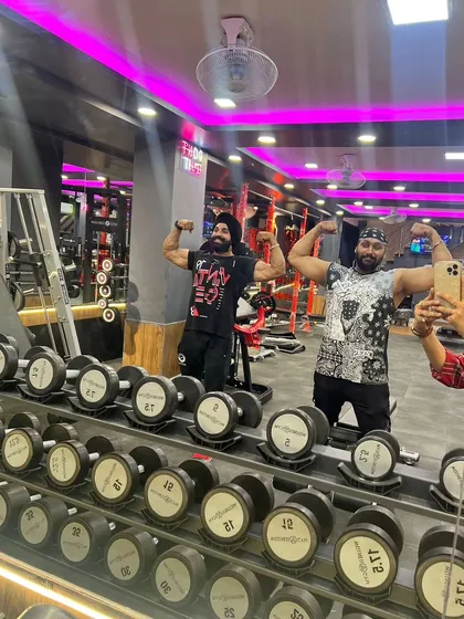 Hitting a double bicep pose with a training partner. The gym is about pushing each other to be better, and I create that supportive yet hardcore environment for my clients.