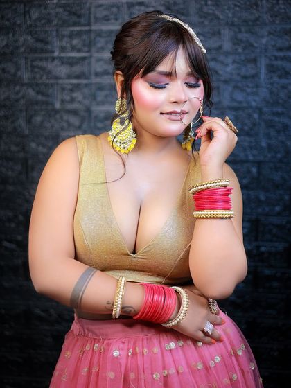 A creative pose that draws attention to the large, colorful earrings and dramatic eye makeup.