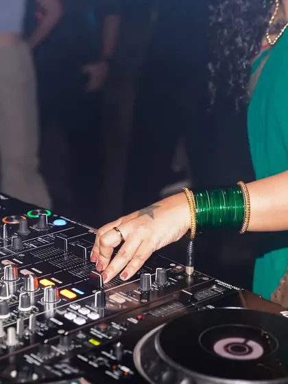 A close-up of my hands on the mixer during a gig. Wearing a saree and playing Drum & Bass is a core part of my identity. I encourage my students to embrace their own culture and bring it into their music.