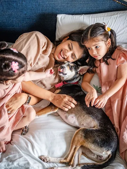 A beautiful moment of love and comfort. A mother and her two young daughters cuddle in bed with Choco, their rescued indie dog. This photo shows the gentle, trusting nature of a dog who has found her safe and loving forever home.