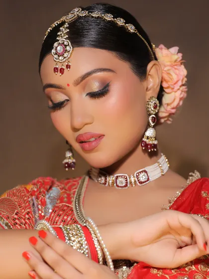 A soft, romantic pose highlighting the delicate details of the bridal makeup, from the floral hair accessory to the subtle shimmer on the eyelids.