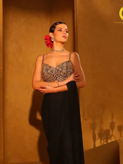 Unveil the beauty of personalized couture. A model looks timelessly elegant in a black drape saree with a heavily embellished bustier.