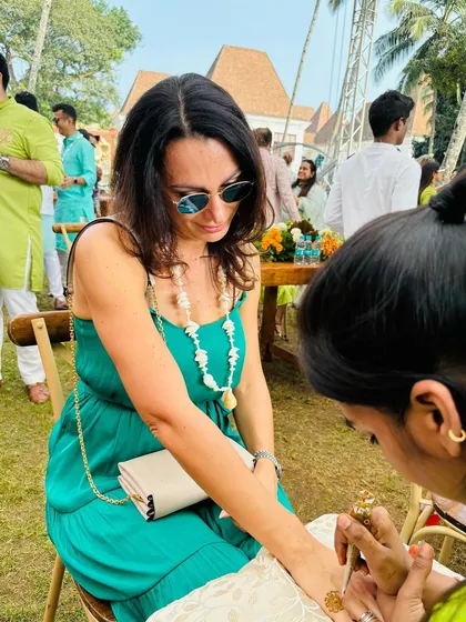My artist carefully applies a design for a guest at a daytime mehndi function. We provide a comfortable and professional setup for your guests to enjoy.