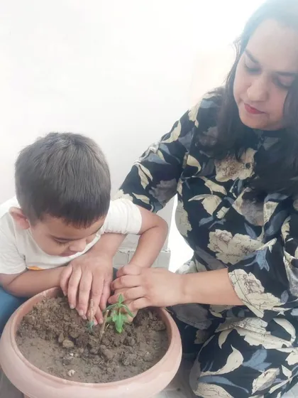 A mother guides her son's hands as they plant a new life, a touching moment from our "Ek Ped Maa Ke Naam" campaign.