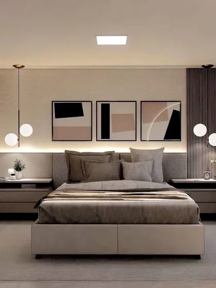 A sophisticated bedroom with a neutral color palette and abstract art. The pendant lights and fluted wall panels add layers of texture and light.