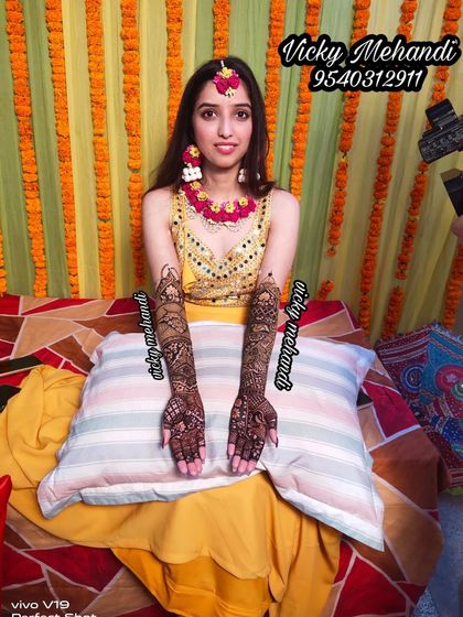 A beautiful bride posing with her completed mehndi. Capturing this happy moment is part of the experience.