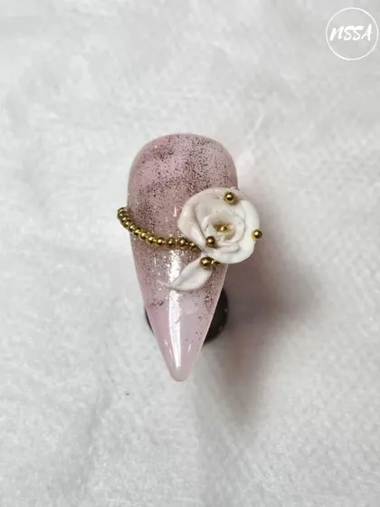 An elegant 3D white rose on a glittery pink base, crafted by a student. This piece shows their skill in sculpting delicate petals and using embellishments.