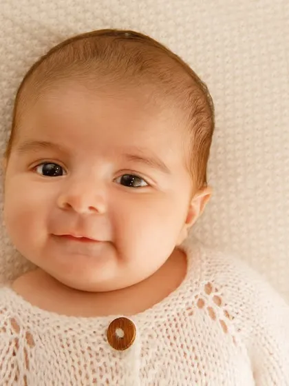The sweetest, most gentle smile from a baby in a cozy knit sweater. Close-up portraits like this really capture their innocent expressions.