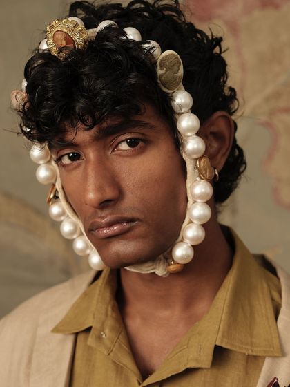 A striking close-up portrait from the Cord "Vinyl Echoes" shoot, featuring unique headwear and styling.
