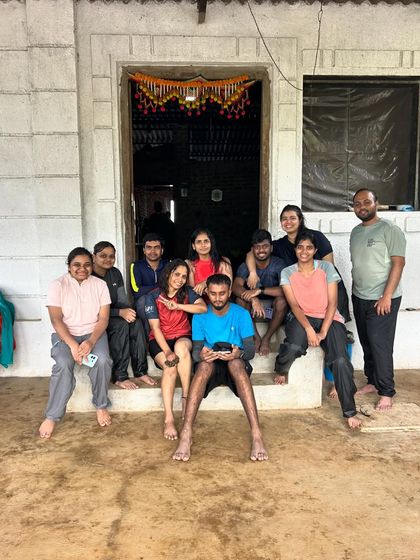 A group relaxing on the steps of a village house in Maharashtra, a moment of rest between adventures.