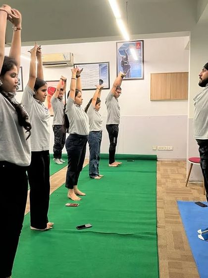 Leading a class through Tadasana (Mountain Pose) with raised arms at SA Consultant.