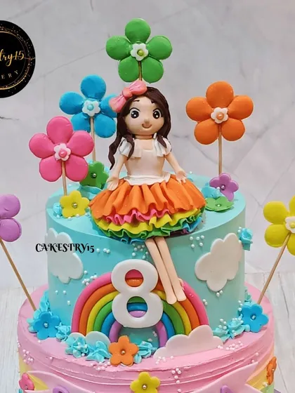 A close-up of the charming doll topper on the 8th birthday cake. The handcrafted figure and colorful fondant flowers showcase our attention to detail in creating personalized cakes.