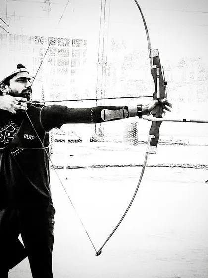 A moment of pure focus captured in black and white. This image highlights the mental stillness and concentration required to execute a perfect shot and hit the bullseye under pressure.