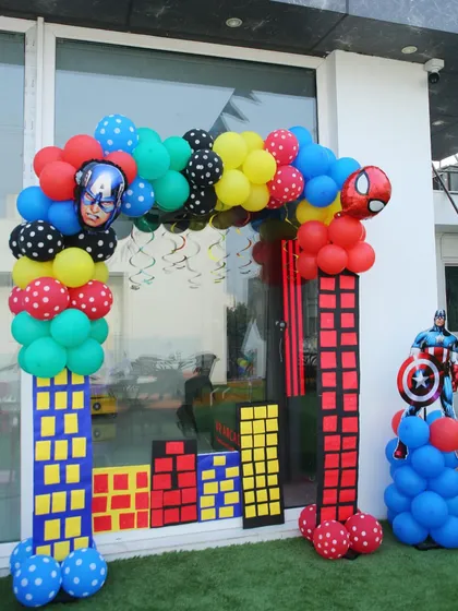 An action-packed entrance for a superhero party with balloon columns designed to look like city buildings.