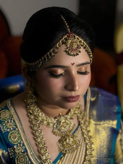 An eyes-closed shot to highlight the soft, golden eye makeup that complements her traditional attire.