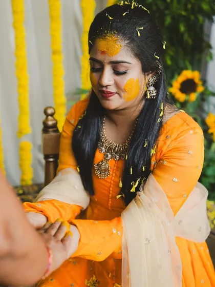 A quiet moment during the Haldi rituals. The decor is simple yet elegant, with yellow flower arrangements that complement the traditional ceremony.