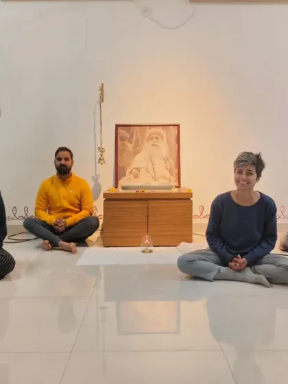 A small group of participants sit with smiles after a transformative Surya Kriya session, their faces reflecting a newfound sense of peace.