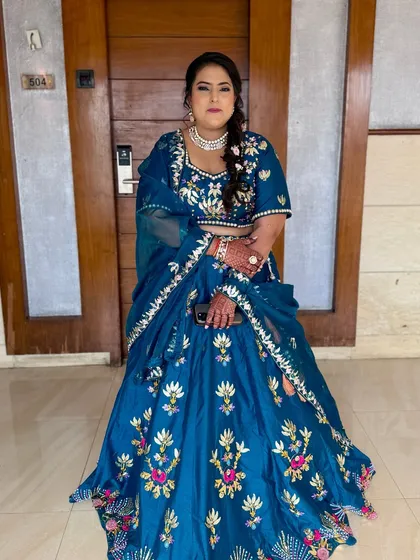 A full-length shot of the bride in her royal blue lehenga. The makeup is balanced and elegant, perfect for an evening event.