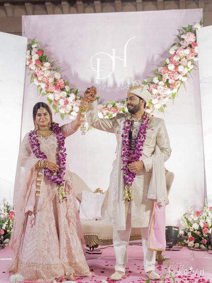 The couple raises their hands in celebration, a moment of shared victory and happiness. We capture the energy and excitement of the day.