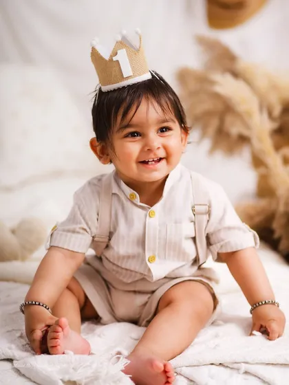 A joyful, candid shot of the birthday boy. The soft, neutral tones of the boho setup create a calm and beautiful atmosphere.