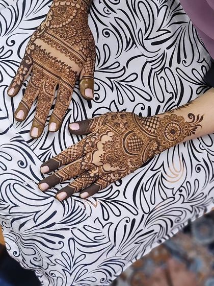This design combines many different elements, from filled fingertips and detailed finger bands to a circular mandala and floral patterns extending to the wrist.