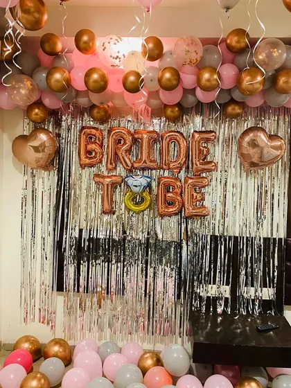 A chic and modern photo booth I designed for a bride-to-be party. This setup uses a popular color scheme of rose gold, pink, and grey balloons, with a shimmering silver fringe backdrop. The large 'BRIDE TO BE' foil balloons, complete with a diamond ring detail, make it a perfect spot for pictures.