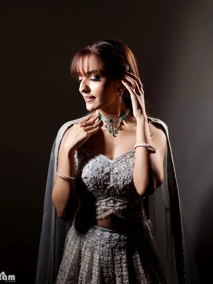 A stunning bridal portrait using dramatic side lighting. The light beautifully sculpts her features and highlights the intricate details of her jewelry and gown, creating a moody and elegant look.