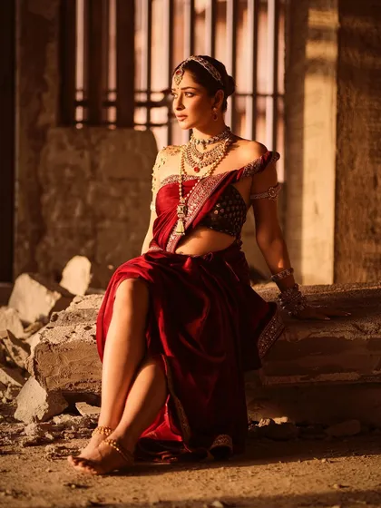 This shot captures a modern yet traditional feel, with Nyra Banerjee in a powerful pose. The unique saree drape and the contrast with the raw, unfinished background create a high-fashion editorial image.