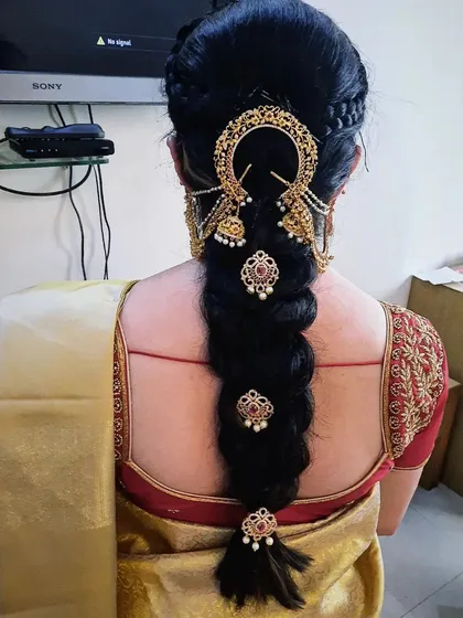 This is a classic leaf braid, also known as a fishtail braid, decorated with traditional gold accessories. It’s a popular choice for weddings and other grand functions.