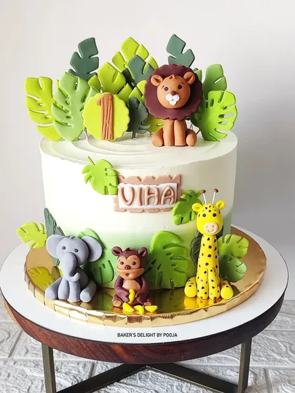 The full view of this popular jungle safari cake, featuring a friendly lion, a curious monkey, a gentle elephant, and a tall giraffe. This design is perfect for celebrating a first birthday in style.