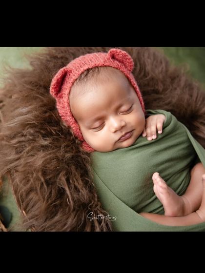 Another angle of the bear bonnet shoot, showing the baby's tiny feet peeking out of the wrap.