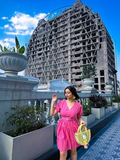 Feeling like I'm in a movie with the wind as my paid actor! This vibrant pink short dress paired with a yellow bag and pink heels is a perfect example of dopamine dressing for a happy summer afternoon.