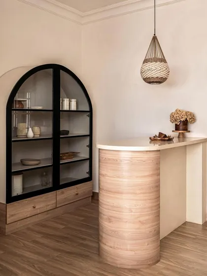This custom-designed bar area from the Ivy Lane Villa project highlights my ability to create unique entertainment spaces. The curved light oak bar, paired with an arched glass cabinet, creates a sophisticated focal point for hosting that blends seamlessly with the home's elegant aesthetic.