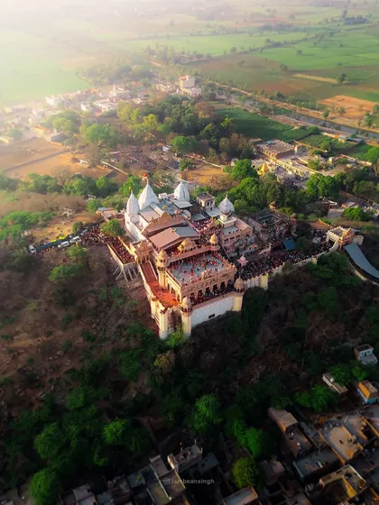 A drone photograph of the Shri Radha Rani Temple in Barsana. This high-angle view captures the temple's magnificent architecture and its location on a hilltop overlooking the town.